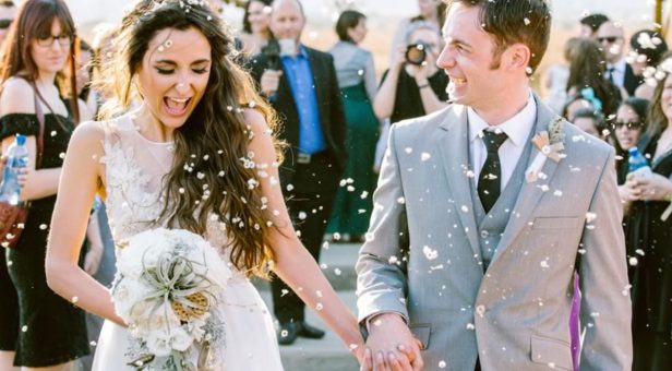 Image of A Happiest Bride and Groom Holding Hands Each other in their Wedding Ceremony With Full Of Joy.