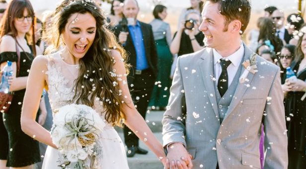 Image of A Happiest Bride and Groom Holding Hands Each other in their Wedding Ceremony With Full Of Joy.