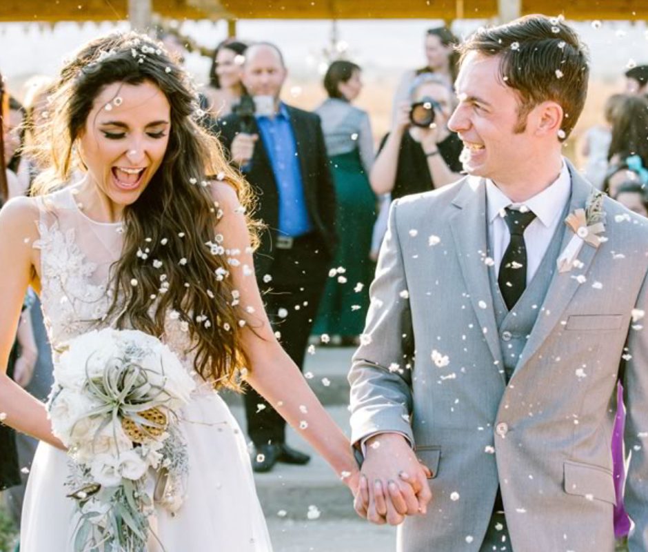 Image of A Happiest Bride and Groom Holding Hands Each other in their Wedding Ceremony With Full Of Joy.