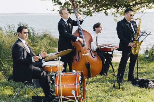 Image Showing The Quartet of Wedding Musicians Playing Their Instruments In An Outdoor Party.