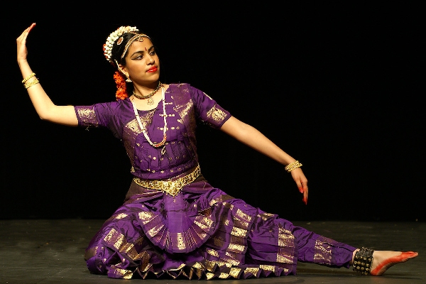 An Image of a girl performing a sitting pose in Bharatnatyam