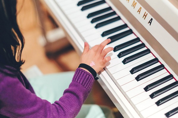 A closeup of a small girl's hand playing piano.