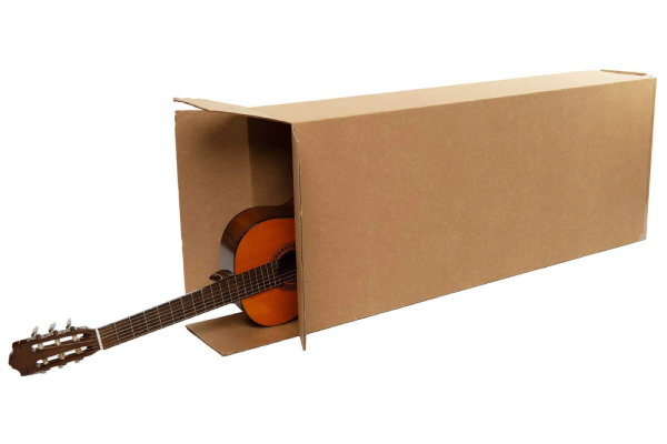 A guitar inside a carton box, a bit of its top portion is seen.